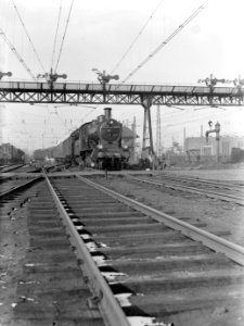Locomotief van de serie 3700 (3808) verlaat het Centraal Station in Amsterdam, Bestanddeelnr 189-0176