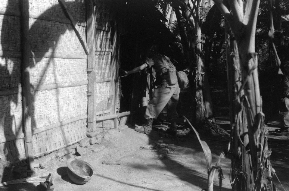 Lid van een patrouille opent de deur van een huis, Bestanddeelnr 6464