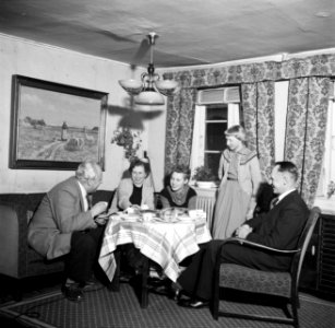 Links Willem van de Poll drinkt koffie met het gezin Dirchsen in hun woonkamer, Bestanddeelnr 252-8780