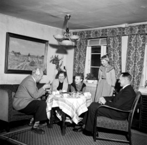 Links Willem van de Poll drinkt koffie met het gezin Dirchsen in hun woonkamer, Bestanddeelnr 252-8779