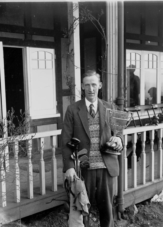 Man holding a set of golf clubs and a cup (1294513)