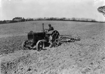 Man harrowing with tractor and disk harrow (1295027)