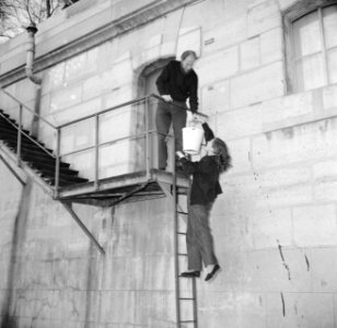 Man en vrouw bij het doorgeven van een emmer op de trappen langs de Seinekade in, Bestanddeelnr 252-9403