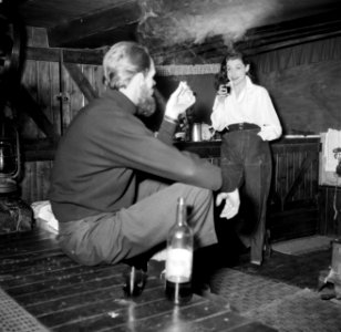 Man en vrouw, wijn drinkend en sigaretten rokend aan boord van het schip Siegfri, Bestanddeelnr 252-9413