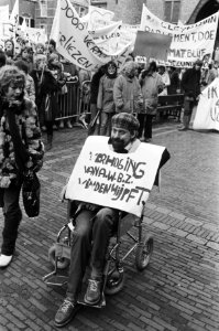 Man in rolstoel met een sandwichbord, Bestanddeelnr 932-4956
