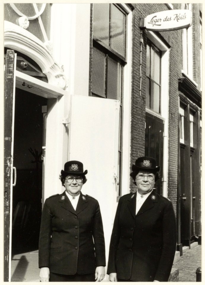 Majoor F. Dijkstra (links) en majoor A. Dijkstra voor het gebouw van het Leger des Heils aan de Schagchelstraat. NL-HlmNHA 54005154