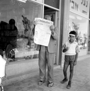 Man verbergt gezicht achter Franstalige krant L'Information d'Israël, naast hem , Bestanddeelnr 255-3084