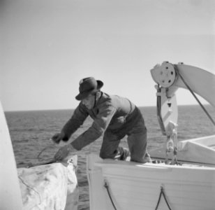 Man verricht werkzaamheden aan de reddingsboten van een schip, Bestanddeelnr 255-0009