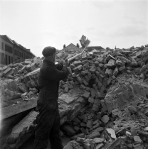 Man bezig met het ruimen van puin, Bestanddeelnr 900-4250