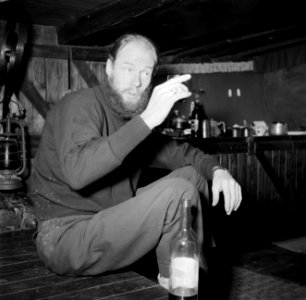 Man, wijn drinkend en sigaretten rokend aan boord van het schip Siegfried & Erik, Bestanddeelnr 252-9416