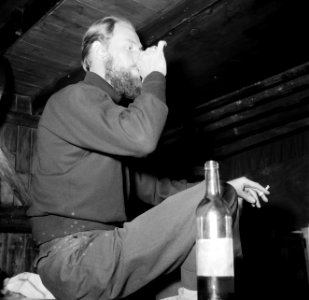 Man, wijn drinkend en sigaretten rokend aan boord van het schip Siegfried & Erik, Bestanddeelnr 252-9415