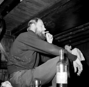Man, wijn drinkend en sigaretten rokend aan boord van het schip Siegfried & Erik, Bestanddeelnr 252-9414