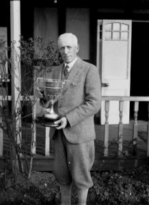 Man outside Llandrindod Wells Golf Club pavilion, with the Llandrindod Golf Club cup (1294303)