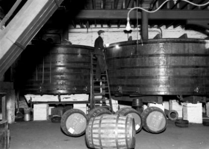 Man inspecteert de vaten waarin whisky wordt bewaard, Bestanddeelnr 252-1276