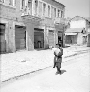 Man met baby in een deken gewikkeld al lopend door de straten van Mea Shearim, Bestanddeelnr 255-2472