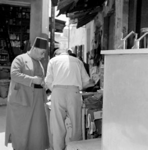 Man met een fez op in gesprek met een handelaar, Bestanddeelnr 255-3238 photo