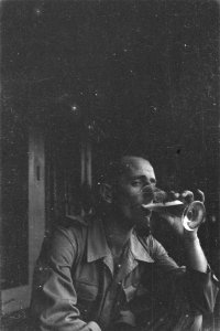 Man met mouwembleem Public Relations drinkt een glas bier, Bestanddeelnr 228-2-3