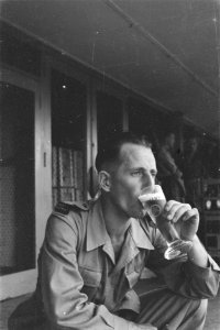Man met mouwembleem Public Relations drinkt een glas bier, Bestanddeelnr 228-2-2