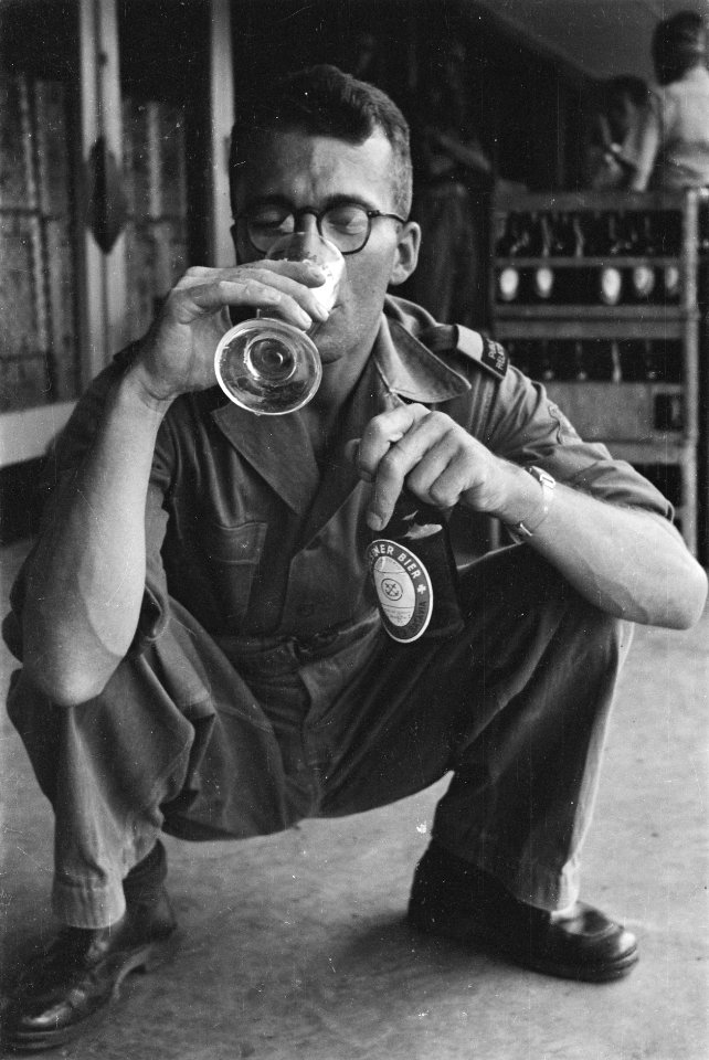 Man met mouwembleem Public Relations drinkt een glas bier, Bestanddeelnr 228-2-4