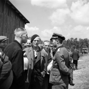 Man in uniform in gesprek met mannen in burgerkleding, Bestanddeelnr 900-3394