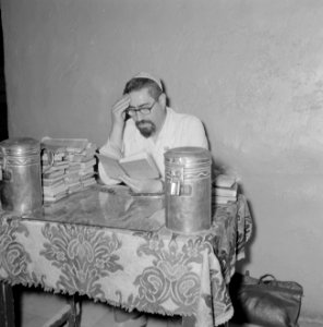 Man leest boeken, vermoedelijk de bewakergastheer van Het Graf van David, Bestanddeelnr 255-2329