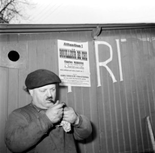 Man steekt een pijp op in de beschutting van de keet, Bestanddeelnr 252-9482