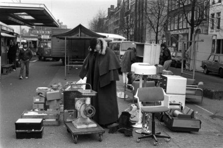 Man op Waterlooplein warmt zich in (te) grote jas, Bestanddeelnr 933-5604