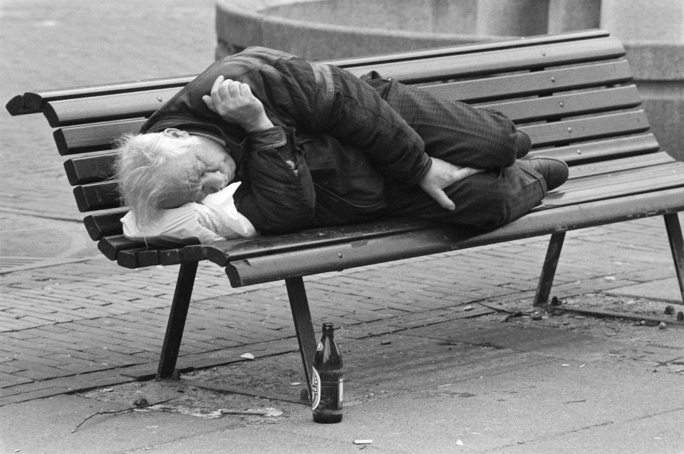 Man slaapt op bankje buiten met voor zich een bierfles, Bestanddeelnr 934-2061