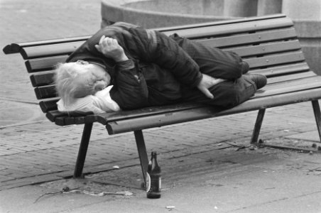 Man slaapt op bankje buiten met voor zich een bierfles, Bestanddeelnr 934-2061