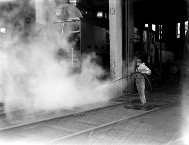 Man spuit een stoomlocomotief schoon, Bestanddeelnr 252-1024