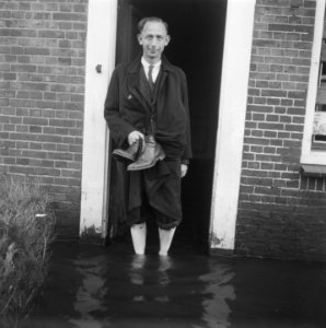 Man staat bij voordeur met voeten in het water, Bestanddeelnr 900-7536