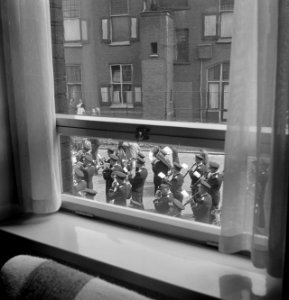 Marcherend muziekkorps gezien vanuit raam, Bestanddeelnr 255-8442