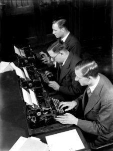 Mannen aan schrijfmachines in de werkkamer van de administratie in het gebouw op, Bestanddeelnr 189-1308