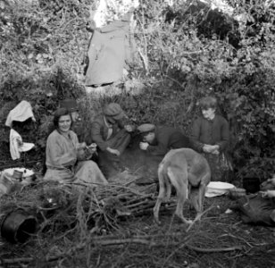 Mannen en vrouwen zittend om het kampvuur, Bestanddeelnr 191-0824