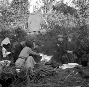 Mannen en vrouwen zittend om een kampvuur, Bestanddeelnr 191-0823 photo