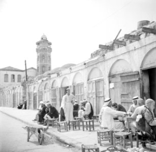 Mannen op een terras, vermoedelijk bij een theehuis op de achtergrond de minare, Bestanddeelnr 255-0104