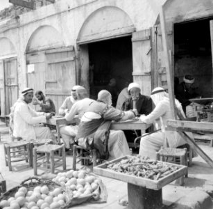 Mannen op een terras naast een groentewinkel, Bestanddeelnr 255-0109