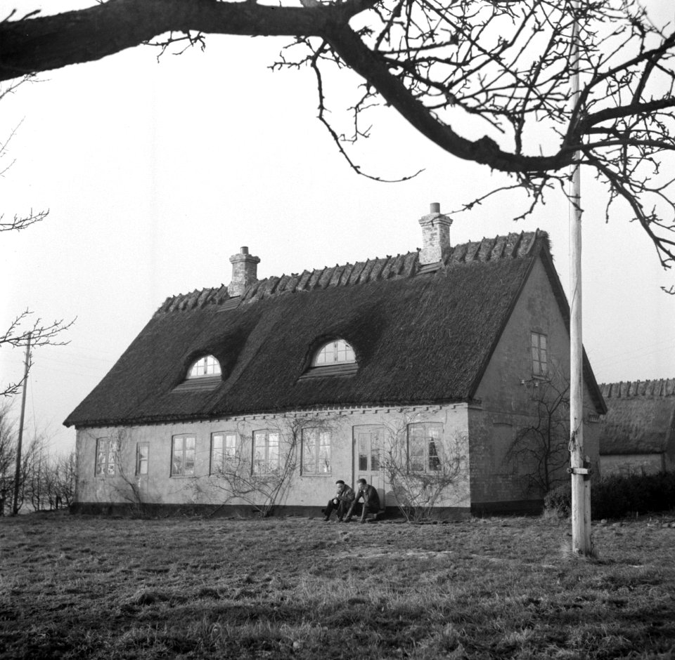 Mannen zitten op een stoep voor een deur van een boerderij in Rønnede op Seeland, Bestanddeelnr 252-8864