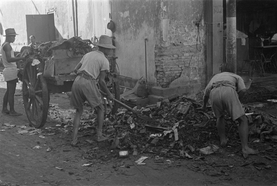 Mannen bezig met opruimen van puin bij een verwoest gebouw in Palembang, Bestanddeelnr 125-5-5