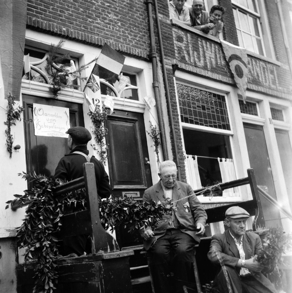 Mannen versieren hun woning in de Jordaan. Op de deur staat aangeplakt Aanmeld, Bestanddeelnr 900-4545