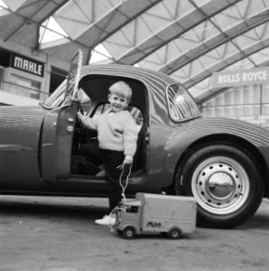 Maarten bekijkt met zijn speelgoedauto op zijn gemak MG-coupe nu de RAI achter d, Bestanddeelnr 912-0932