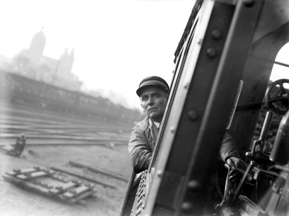 Machinist kijkt uit het zijraam van een stoomlocomotief 3909 met op de achtergro, Bestanddeelnr 189-1196