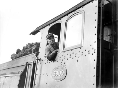 Machinist kijkt uit het zijraam van een stoomlocomotief 3909, Bestanddeelnr 189-1195