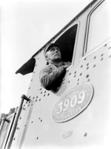Machinist kijkt uit het zijraam van een stoomlocomotief 3909, Bestanddeelnr 189-1194