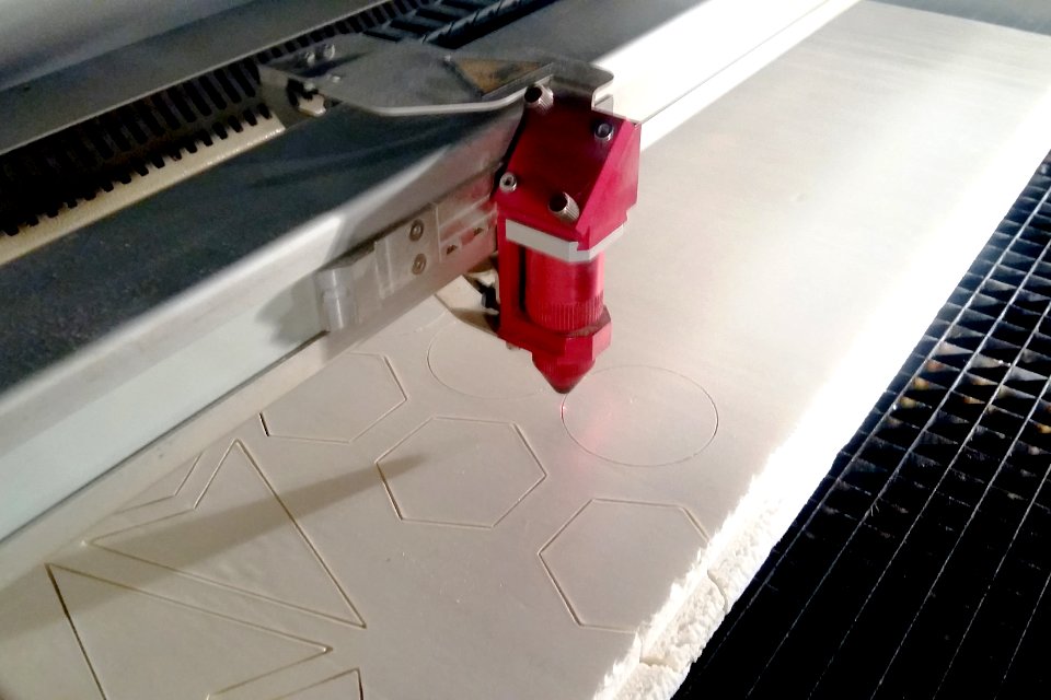 Machine de découpe laser en train de couper des formes géométriques sur du polystyrène expansé, La Villette, Paris, Février 2017