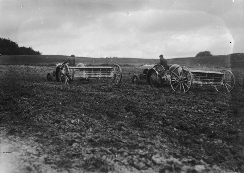 Men on tractors pulling agricultural implements (1294205)
