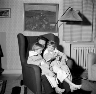 Meneer Svendsen met zijn dochters op schoot, vermoedelijk het voorlezen voor het, Bestanddeelnr 252-8756