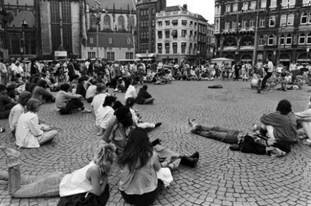 Mensen op de Dam luisteren naar straatmuzikant, Bestanddeelnr 933-3676