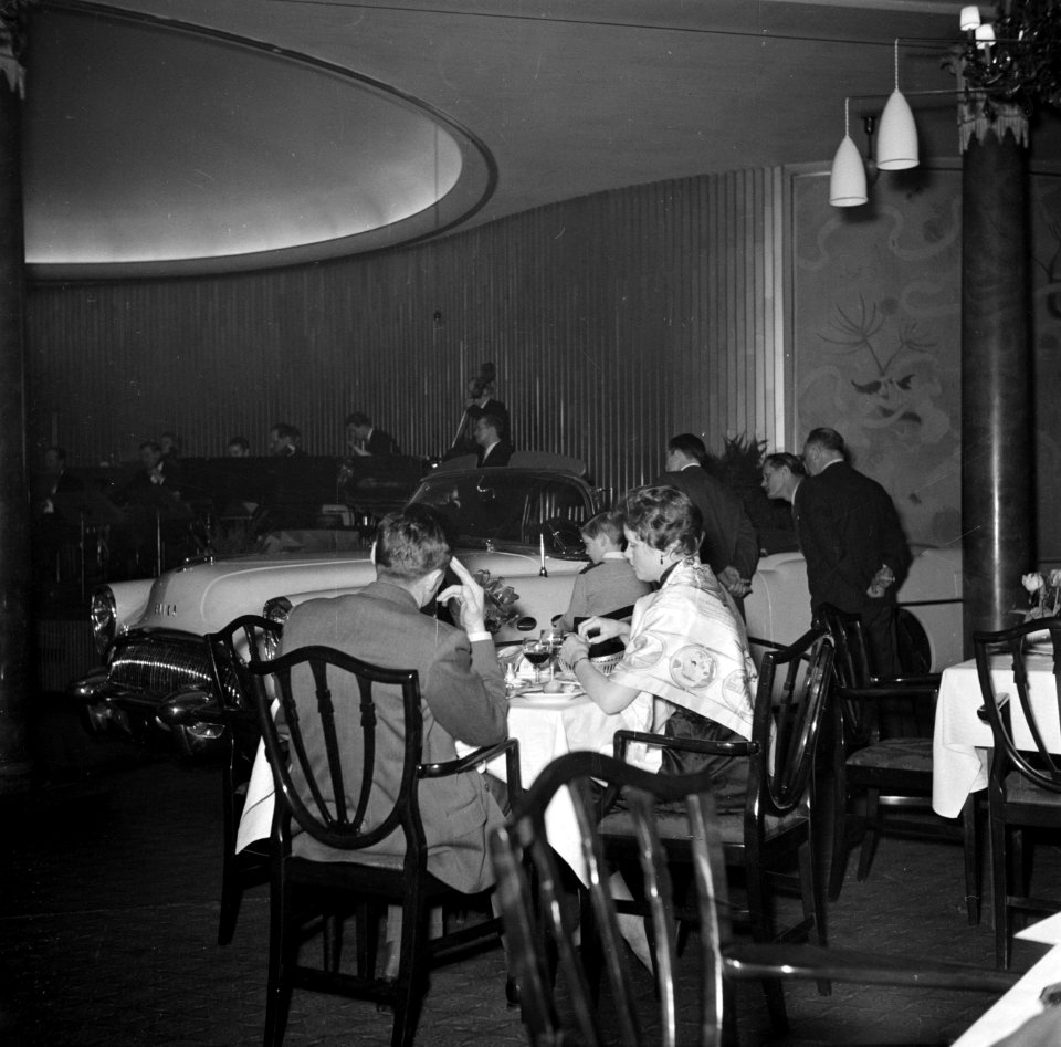 Mensen zitten te eten in restaurant Wivex waar een autoshow wordt gehouden, Bestanddeelnr 252-9165