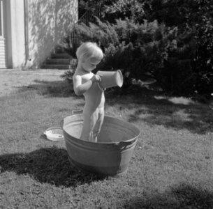 Meisje spelend met een teil water in de tuin van de woning van Bachmann, Bestanddeelnr 254-4617
